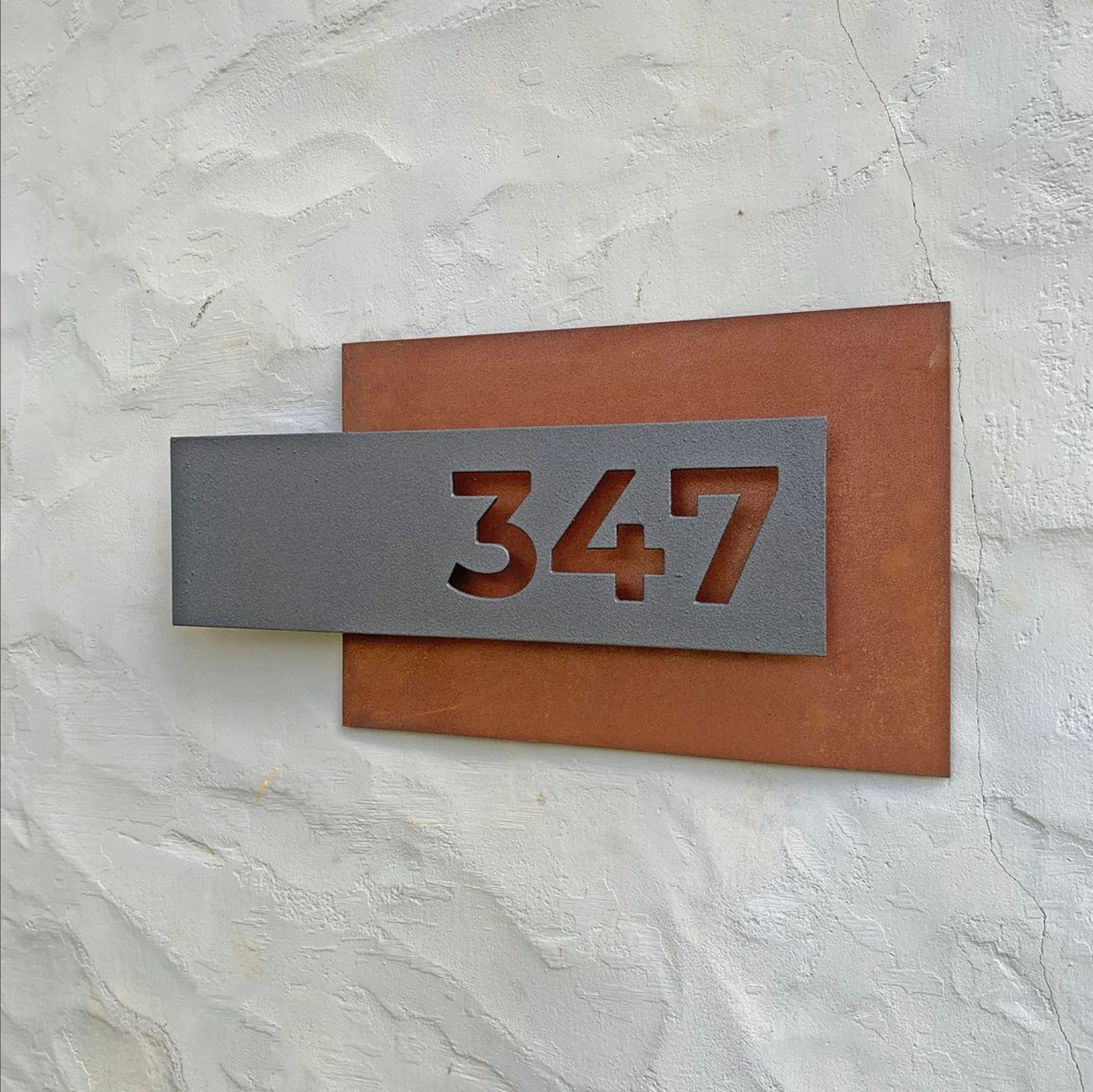 Número de puerta con fondo de acero oxidado