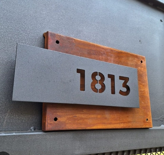 Número de puerta con fondo de acero oxidado